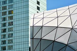 Abstract closeup of the glass-clad facade of a modern building covered in reflective plate glass. Architecture abstract background. Glass wall and facade detail. photo