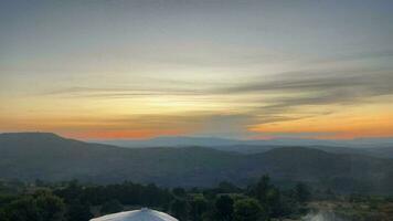 Tailândia pôr do sol filmado dentro uma Tempo lapso com nuvens comovente sobre uma montanha. video