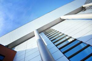 Abstract closeup of the glass-clad facade of a modern building covered in reflective plate glass. Architecture abstract background. Glass wall and facade detail. photo