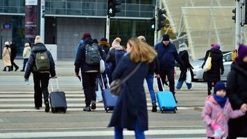 Warsaw, Poland. 29 December 2023. Crowd of people crossing street on traffic light zebra in the city  at rush hour. Lifestyle in a big city in Europa. photo