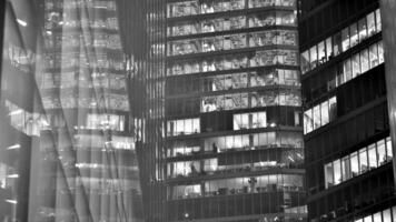 Pattern of office buildings windows illuminated at night. Glass architecture ,corporate building at night - business concept. Black and white. photo