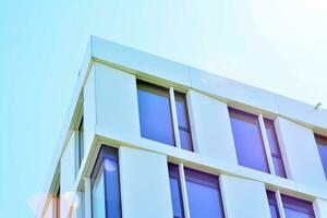 Abstract closeup of the glass-clad facade of a modern building covered in reflective plate glass. Architecture abstract background. Glass wall and facade detail. photo