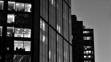 Pattern of office buildings windows illuminated at night. Glass architecture ,corporate building at night - business concept. Black and white. photo