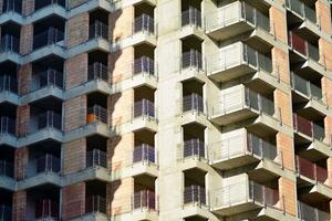 alto subir edificio debajo construcción. instalación de vaso fachada paneles en un reforzado hormigón estructura. foto