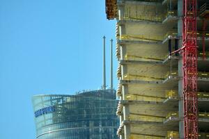 High rise building under construction. Installation of glass facade panels on a reinforced concrete structure. photo