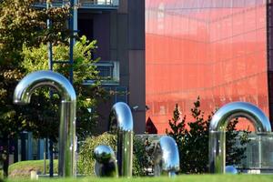 Public art installation in front modern building.Decorative stainless steel pipes photo