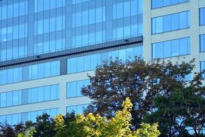 Glass building with transparent facade of the building and blue sky. Structural glass wall reflecting blue sky. Abstract modern architecture fragment. Contemporary architectural background. photo