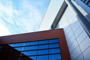 Abstract closeup of the glass-clad facade of a modern building covered in reflective plate glass. Architecture abstract background. Glass wall and facade detail. photo