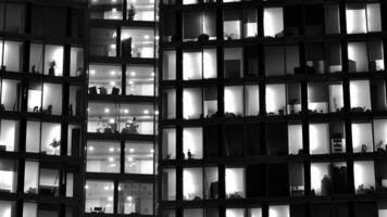 Pattern of office buildings windows illuminated at night. Glass architecture ,corporate building at night - business concept. Black and white. photo