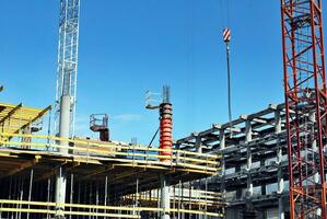 High rise building under construction. Installation of glass facade panels on a reinforced concrete structure. photo