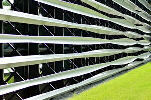 Abstract closeup of the glass-clad facade of a modern building covered in reflective plate glass. Architecture abstract background. Glass wall and facade detail. photo