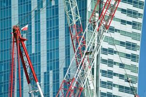 High rise building under construction. Installation of glass facade panels on a reinforced concrete structure. photo