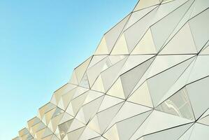 Abstract closeup of the glass-clad facade of a modern building covered in reflective plate glass. Architecture abstract background. Glass wall and facade detail. photo