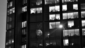 Pattern of office buildings windows illuminated at night. Glass architecture ,corporate building at night - business concept. Black and white. photo