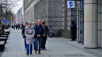 Warsaw, Poland. 29 December 2023. People of different ages and nationalities walk across in the city center, winter time.  People at the street. photo