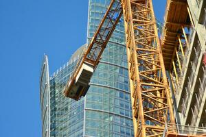 High rise building under construction. Installation of glass facade panels on a reinforced concrete structure. photo