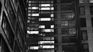 Pattern of office buildings windows illuminated at night. Glass architecture ,corporate building at night - business concept. Black and white. photo