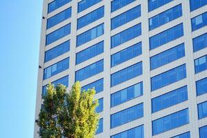 vaso edificio con transparente fachada de el edificio y azul cielo. estructural vaso pared reflejando azul cielo. resumen moderno arquitectura fragmento. contemporáneo arquitectónico antecedentes. foto