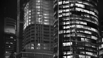 Pattern of office buildings windows illuminated at night. Glass architecture ,corporate building at night - business concept. Black and white. photo