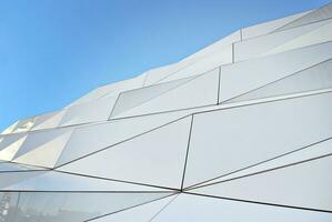 Abstract closeup of the glass-clad facade of a modern building covered in reflective plate glass. Architecture abstract background. Glass wall and facade detail. photo