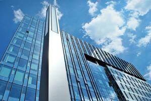 Glass building with transparent facade of the building and blue sky. Structural glass wall reflecting blue sky. photo