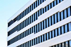 Abstract closeup of the glass-clad facade of a modern building covered in reflective plate glass. Architecture abstract background. Glass wall and facade detail. photo