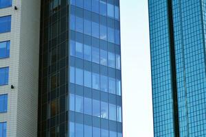 Glass building with transparent facade of the building and blue sky. Structural glass wall reflecting blue sky. Abstract modern architecture fragment. Contemporary architectural background. photo