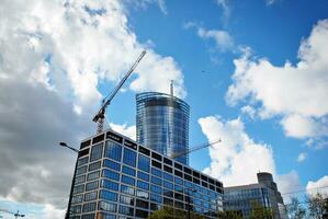 High rise building under construction. Installation of glass facade panels on a reinforced concrete structure. photo