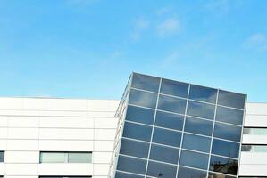 Abstract closeup of the glass-clad facade of a modern building covered in reflective plate glass. Architecture abstract background. Glass wall and facade detail. photo