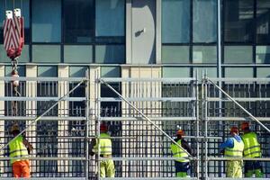 High rise building under construction. Installation of glass facade panels on a reinforced concrete structure. photo