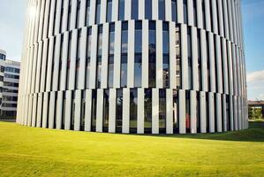 Abstract closeup of the glass-clad facade of a modern building covered in reflective plate glass. Architecture abstract background. Glass wall and facade detail. photo