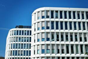 Abstract closeup of the glass-clad facade of a modern building covered in reflective plate glass. Architecture abstract background. Glass wall and facade detail. photo