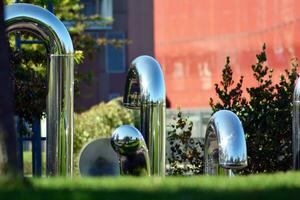 Public art installation in front modern building.Decorative stainless steel pipes photo