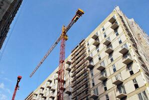 High rise building under construction. Installation of glass facade panels on a reinforced concrete structure. photo