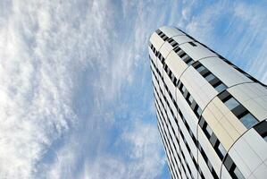 Abstract closeup of the glass-clad facade of a modern building covered in reflective plate glass. Architecture abstract background. Glass wall and facade detail. photo