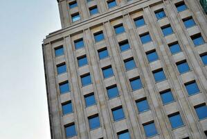 Abstract closeup of the glass-clad facade of a modern building covered in reflective plate glass. Architecture abstract background. Glass wall and facade detail. photo