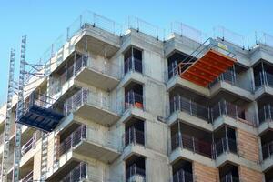 High rise building under construction. Installation of glass facade panels on a reinforced concrete structure. photo