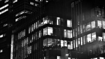 Pattern of office buildings windows illuminated at night. Glass architecture ,corporate building at night - business concept. Black and white. photo