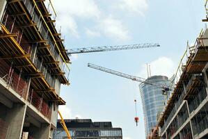 High rise building under construction. Installation of glass facade panels on a reinforced concrete structure. photo