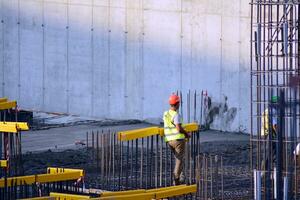 High rise building under construction. Installation of glass facade panels on a reinforced concrete structure. photo