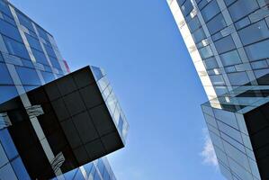 Abstract closeup of the glass-clad facade of a modern building covered in reflective plate glass. Architecture abstract background. Glass wall and facade detail. photo