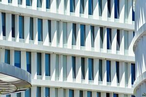 Abstract closeup of the glass-clad facade of a modern building covered in reflective plate glass. Architecture abstract background. Glass wall and facade detail. photo