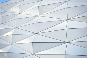 Abstract closeup of the glass-clad facade of a modern building covered in reflective plate glass. Architecture abstract background. Glass wall and facade detail. photo