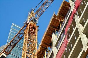 High rise building under construction. Installation of glass facade panels on a reinforced concrete structure. photo