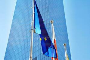 Flaga Unii Europejskiej i polska flaga na tle nowoczesnego budynku. photo