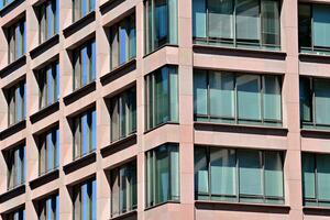 resumen de cerca de el revestido de vidrio fachada de un moderno edificio cubierto en reflexivo plato vaso. arquitectura resumen antecedentes. vaso pared y fachada detalle. foto