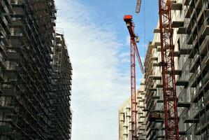 High rise building under construction. Installation of glass facade panels on a reinforced concrete structure. photo