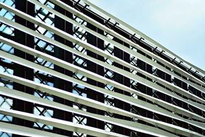 Abstract closeup of the glass-clad facade of a modern building covered in reflective plate glass. Architecture abstract background. Glass wall and facade detail. photo