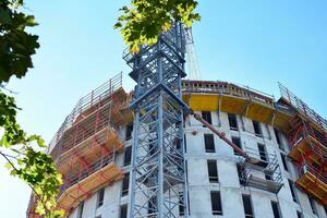 High rise building under construction. Installation of glass facade panels on a reinforced concrete structure. photo