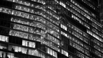 Pattern of office buildings windows illuminated at night. Glass architecture ,corporate building at night - business concept. Black and white. photo